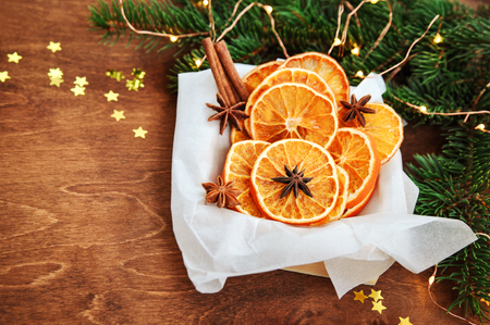 Holiday card for the new year is 2019 in warm, trendy colors. Christmas composition of ingredients for mulled wine orange slices, cinnamon, anise and confetti stars on rustic wooden background.の写真素材