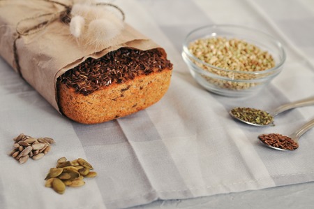 Raw homemade vegan sourdough bread made of green buckwheat with flax seeds, sunflower, pumpkin in a paper Kraft bag. Healthy and proper nutritionの写真素材