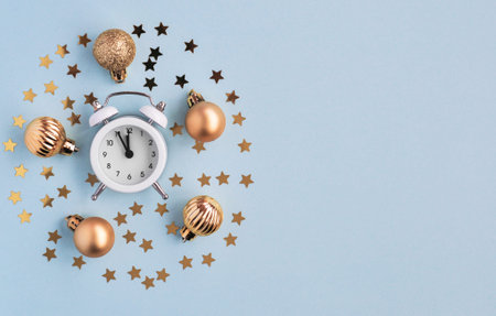 Christmas decor star confetti, gold balls, alarm in the shape of a circle on a blue background,...