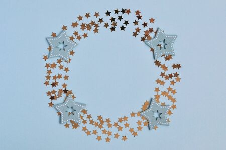 Christmas decor star confetti, wooden ornaments for the Christmas tree in the shape of a circle on a blue background, mint.の写真素材