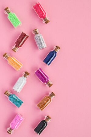 Bright Fashion the concept of small jars with colorful confetti on a pink backgroundの写真素材