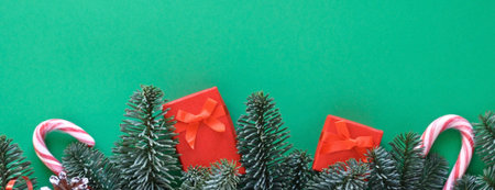 Postcard in the colors of Christmas mood: red gifts, berries, sweets and green fir branches,...