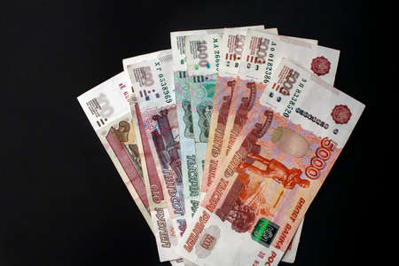 Russian cash money of different value. Close-up of 100, 500, 1000 and 5000 rubles on black background.の写真素材