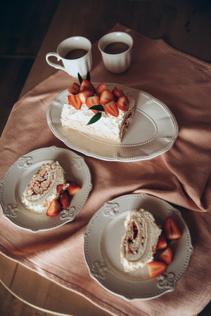 meringue cake combined with fresh strawberries on a background of a pink tableclothの写真素材