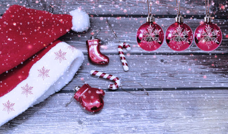 Christmas santa hat and New Year's toys on a wooden snowy background.の写真素材