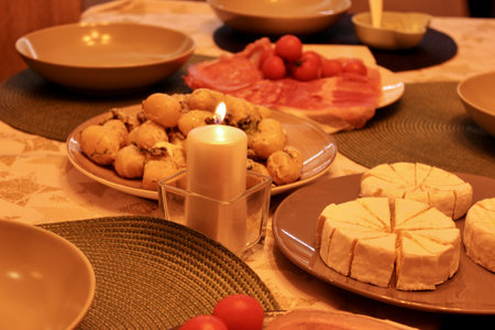 In the evening, a festive table is set in the semi-lit kitchen roomの写真素材