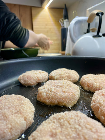 Delicious meat cutlets are being fried in a frying pan in the kitchenの写真素材