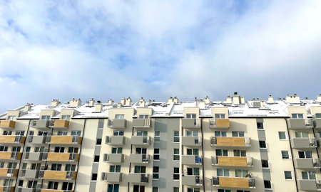 A high-rise building in the city against the background of a blue sky with white cloudsの写真素材