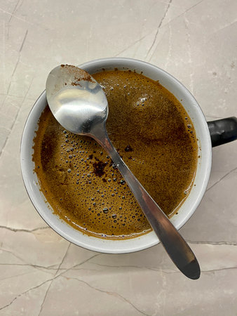 on a gray background, a cup of morning hot coffee and a teaspoonの写真素材