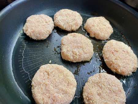 Delicious meat cutlets are being fried in a frying pan in the kitchenの写真素材