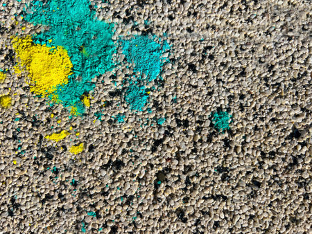 Gray grainy surface background with yellow and blue crushed chalkの写真素材