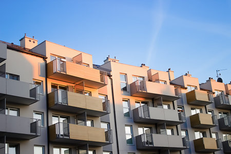A multi-storey gray building with balconies is built in the city. High quality photo