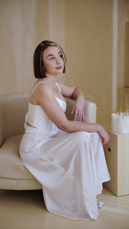A cute girl in a white dress poses with a birthday cake.の写真素材