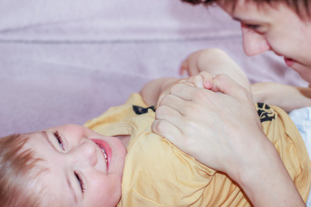 Teenage boy happily playing with his younger brother while looking after him