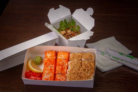 delivery sushi bar udon noodles with chicken, sushi, chopsticks, napkinsの写真素材