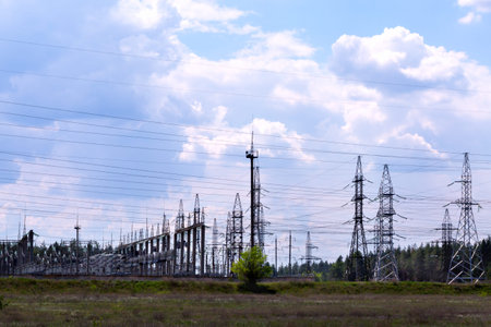 High voltage transmission lines and electric substations with blue sky cloud and forest