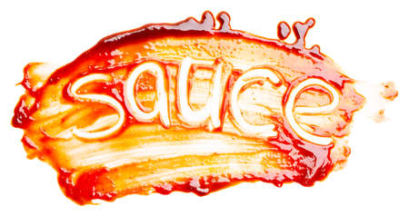 The word SAUCE written with finger on the spilled sauce isolated on white background. Top view, close up.の写真素材