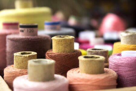 Multicolored reel of thread for sewing, blurred spools, backgroundの写真素材