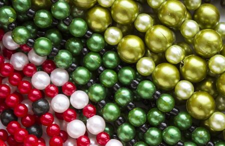 Round multicoloured beads, background. gold, green, red, white and black beadsの写真素材