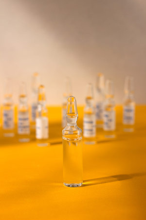 Many ampoules with medicine yellow-gray background, bright light. Medicine concept