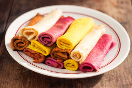 Multi-colored flat pancakes made from natural dyes. Hearty snack, yellow, pink and red pancakesの写真素材
