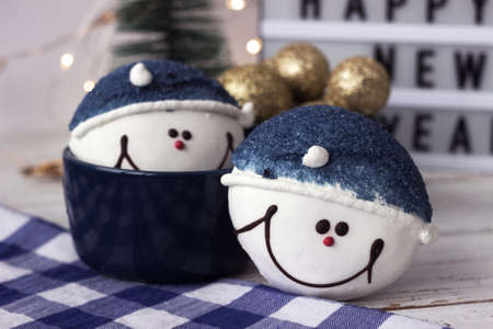 Round cookies in the form of snowmen surrounded by New Year's decor. Blue-white winter goodiesの写真素材