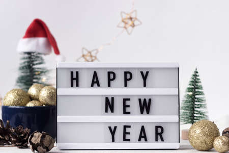 New year concept. Light box with the inscription "Happy New Year", Christmas tree and holiday accessories. White backgroundの写真素材