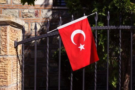 Turkey flag on a stick on a metal fence