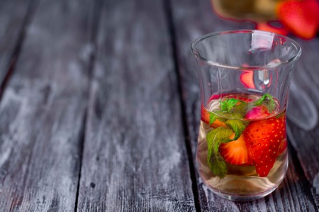 Strawberry lemonade with ice in glass on wooden backgroundの写真素材