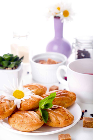 Madeleine homemade cakes in flower shape with tea on white backgroundの写真素材