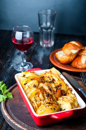 Sliced baked potatoes over wooden background. Rustic style.の写真素材