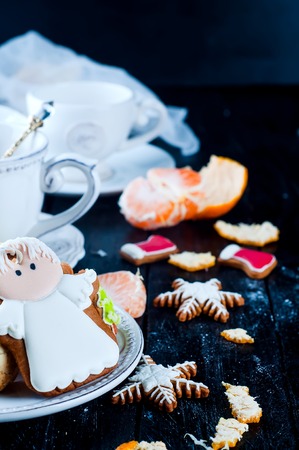 teacup with tea and biscuits on a wooden table on a black backgroundの写真素材