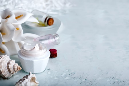 face cream on white background with seashells and flowersの写真素材
