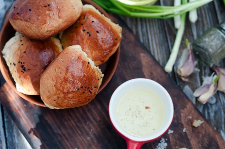 Fresh homemade bread rolls with sesam seed on tableの写真素材
