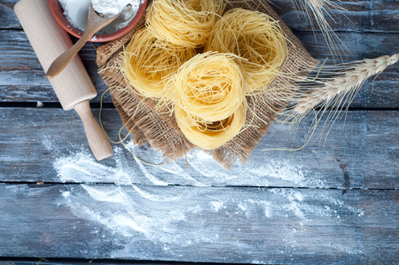 Fresh pasta and ingredients on a boardの写真素材