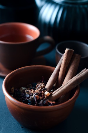 Raw pasta on wooden background and bowl of pastaの写真素材