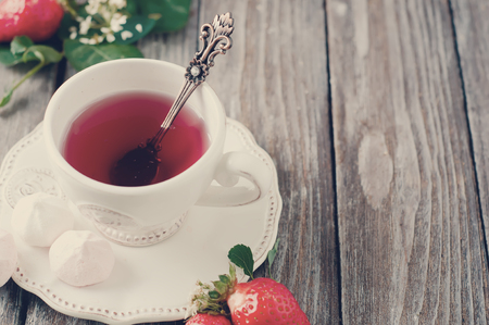 Fruit tea with strawberries on a wooden tableの写真素材