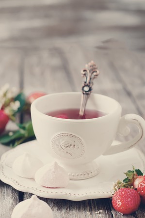 Fruit tea with strawberries on a wooden tableの写真素材