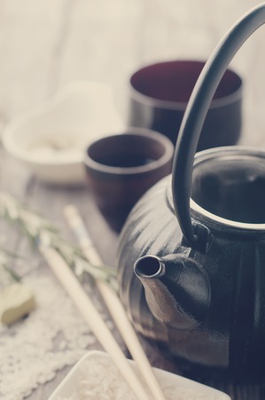 asian tea set and rose petals on the wooden backgroundの写真素材