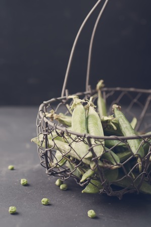 The green peas in basket on table.Toned photoの写真素材