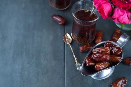 Traditional arabic tea and dry dates. roses in the backgroundの写真素材