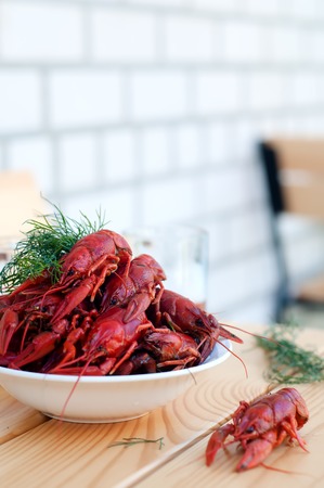 Boiled crayfishes with greenery on a plate in the tableの写真素材
