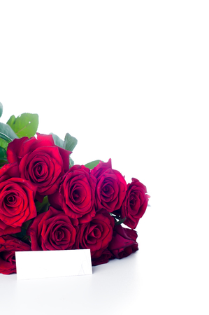 Card and red roses on white backgroundの写真素材