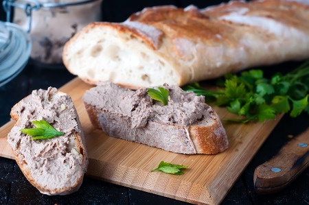 mousse, pate in a jar with a baguette and parsley on a wooden background darkの写真素材