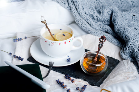 Wooden tray with coffee and honey on the bed with white linenの写真素材