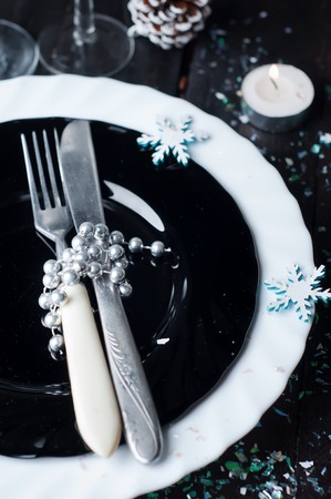 Christmas table setting with pine cones and candles on a dark background . Holiday decorationの写真素材