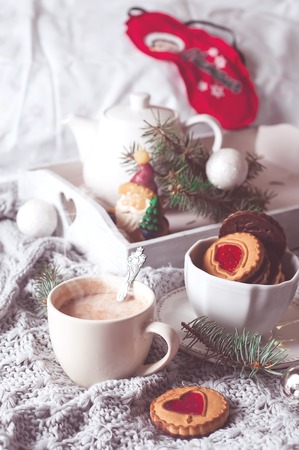 christmas breakfast with coffee and cookies in bed with gray blanket.の写真素材