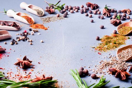 wooden spoons with spices and herbs on textured gray table. space for textの写真素材