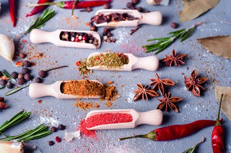 Aromatic spices on wooden spoons on a concrete background . Food ingradients.の写真素材
