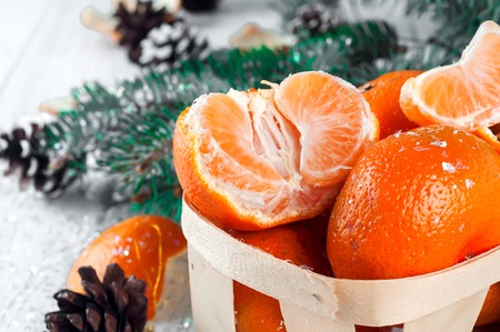 new year composition in basket with mandarins and fir tree on a wood white backgroundの写真素材